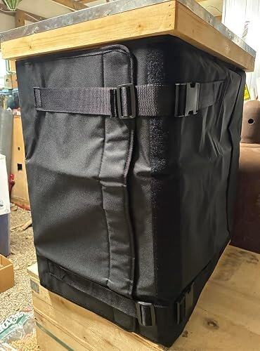 Bee WinterGuard on a wooden hive with both buckle straps visible.